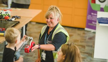 Staff handing a child a toy from our reuse centre